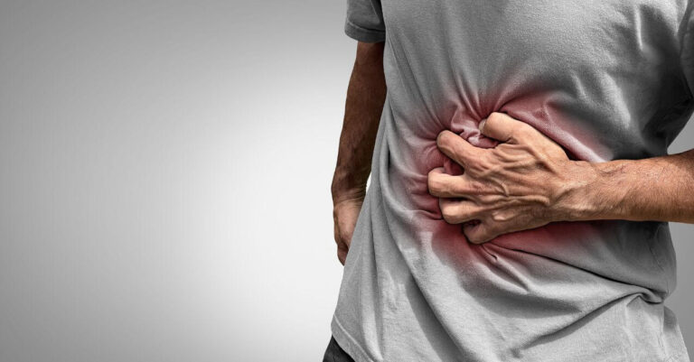 A person clutching their side in pain, resembling 'Can Gallstone Cause Elevated Liver Enzymes'.