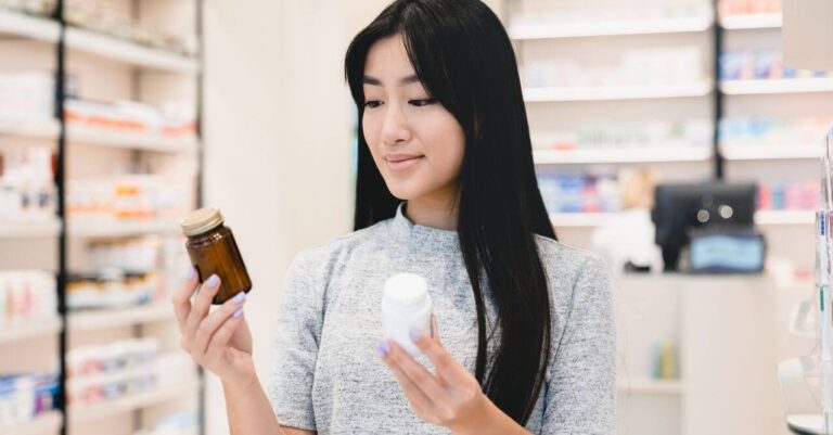 A woman holding two different supplement bottles, resembling 'Magnesium Citrate vs Glycinate'.